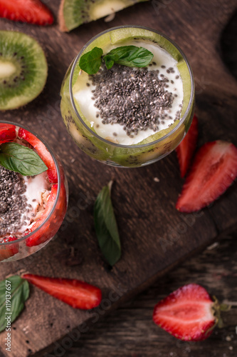 Healthy breakfast or morning snack with chia seeds granola, strawberries and kiwi, vegetarian food, diet and health concept
