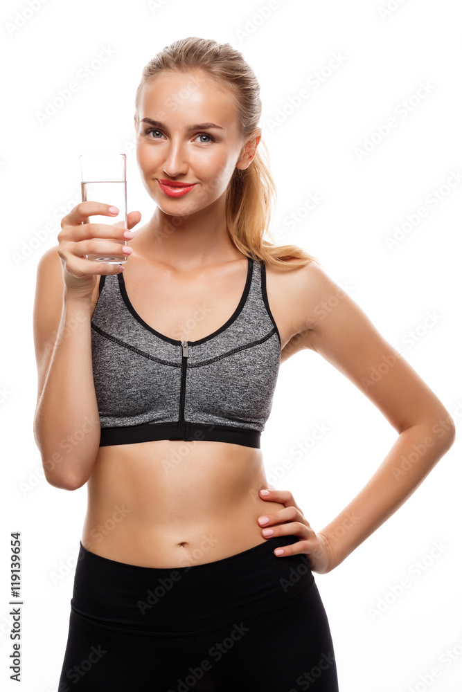 Beautiful sportive girl posing, holding glass of water over white background. Beautiful sportive girl posing, holding glass of water over white background.