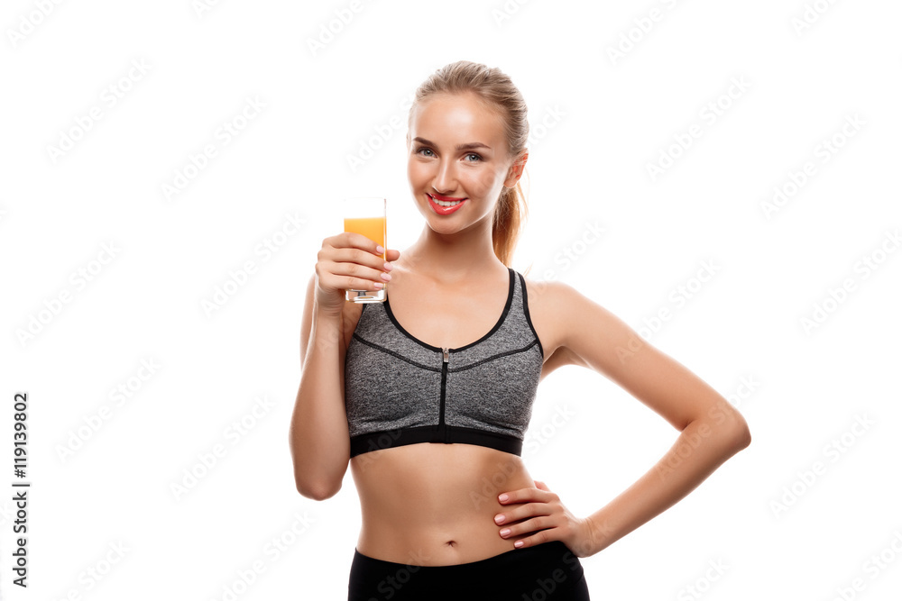 Beautiful sportive girl holding glass with juice over white background.