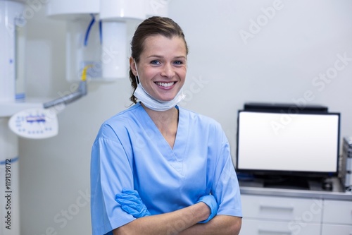 Smiling dental assistant standing with arms crossed photo