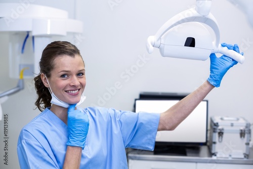 Tableau sur toile Portrait of dental assistant adjusting light
