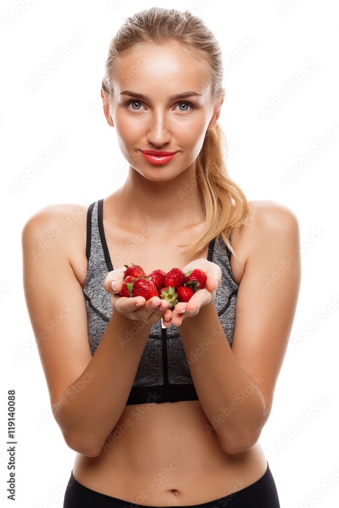 Beautiful sportive girl posing, holding strawberry over white background. Beautiful sportive girl posing, holding strawberry over white background.