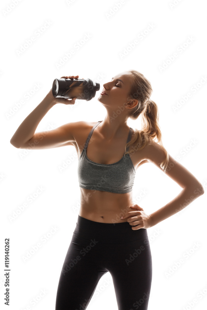 Beautiful sportive girl holding bottle, posing over white background. Beautiful sportive girl holding bottle, posing over white background.