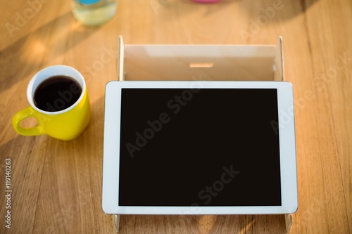 Digital tablet and a cup of coffee on table