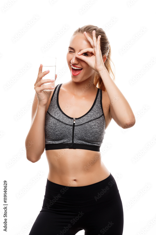 Beautiful sportive girl posing, holding glass of water over white background. Beautiful sportive girl posing, holding glass of water over white background.