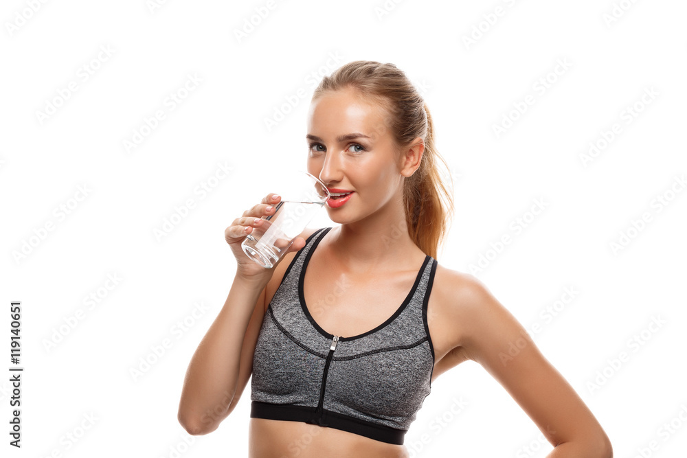 Beautiful sportive girl posing, holding glass of water over white background. Beautiful sportive girl posing, holding glass of water over white background.