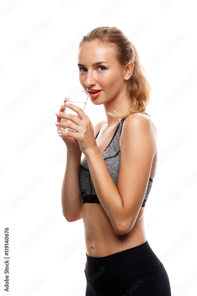 Beautiful sportive girl posing, holding glass of water over white background. Beautiful sportive girl posing, holding glass of water over white background.
