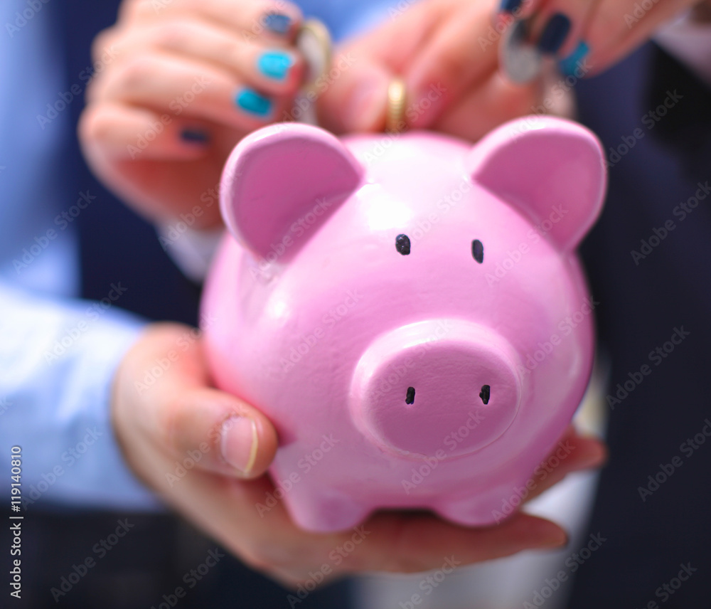 Businessman holding piggy box ,standing in office Businessman holding piggy box ,standing in office