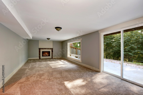 Empty long living room interior with carpet floor and fireplace.