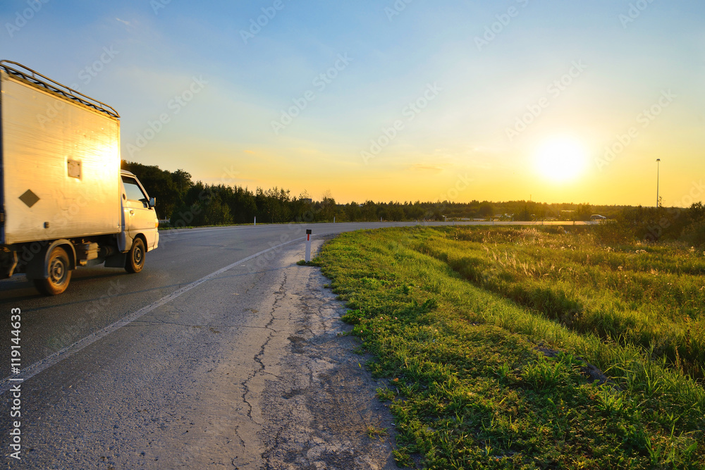 The car rides towards the Sun at sunset