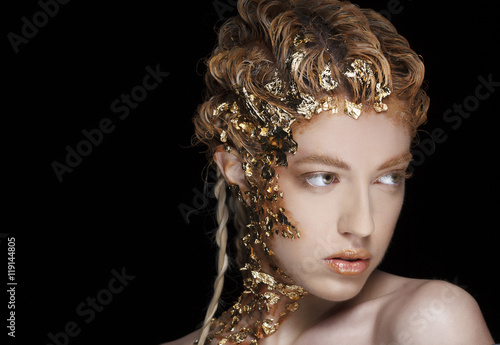 Portrait of beautiful model with shiny foil on face and hair