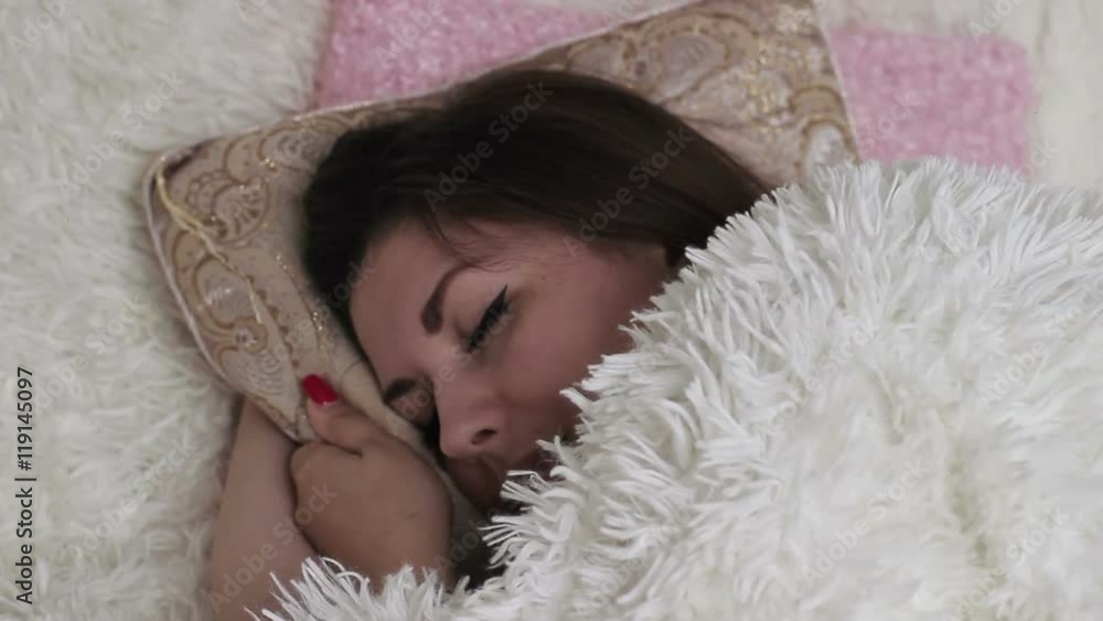 Pretty girl sleeping in bed hugging her pillow and smiling in her sleep Pretty girl sleeping in bed hugging her pillow and smiling in her sleep