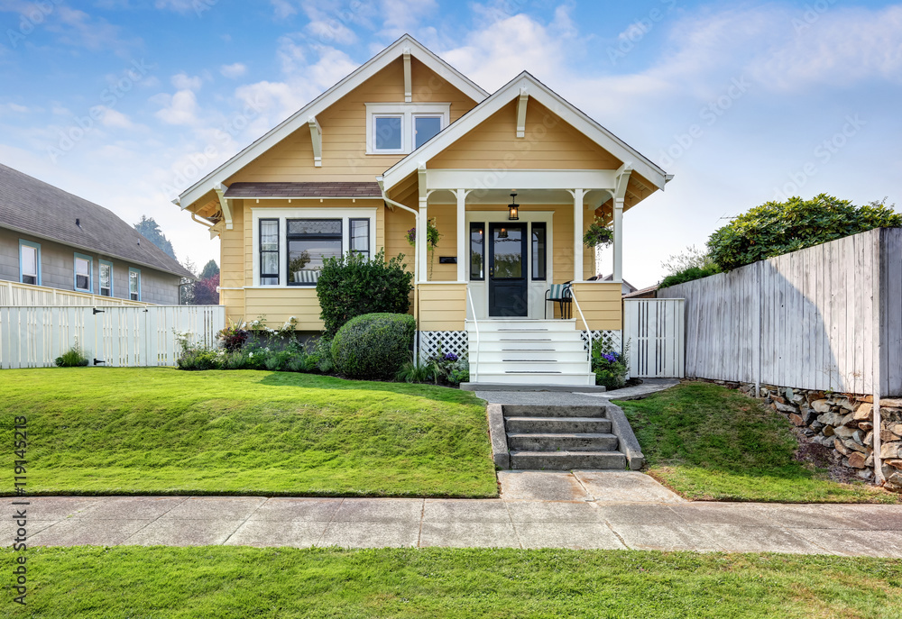 American craftsman home with yellow exterior paint. American craftsman home with yellow exterior paint.