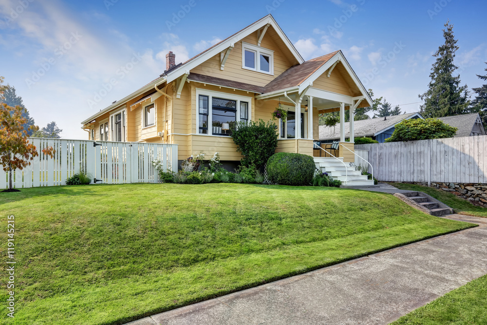 American craftsman home with yellow exterior paint.