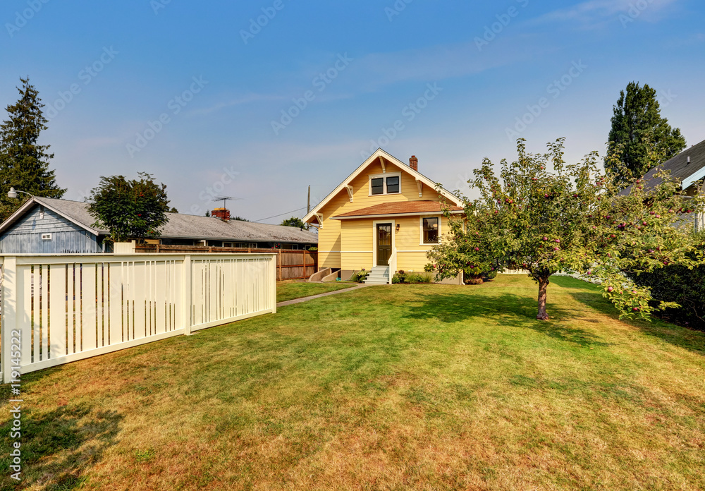 Obraz premium Backyard view of yellow siding craftsman house.