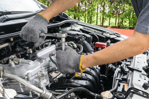 Hands of car mechanic in auto repair service.