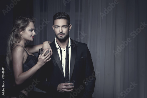 Rich macho young man drink whiskey with lover