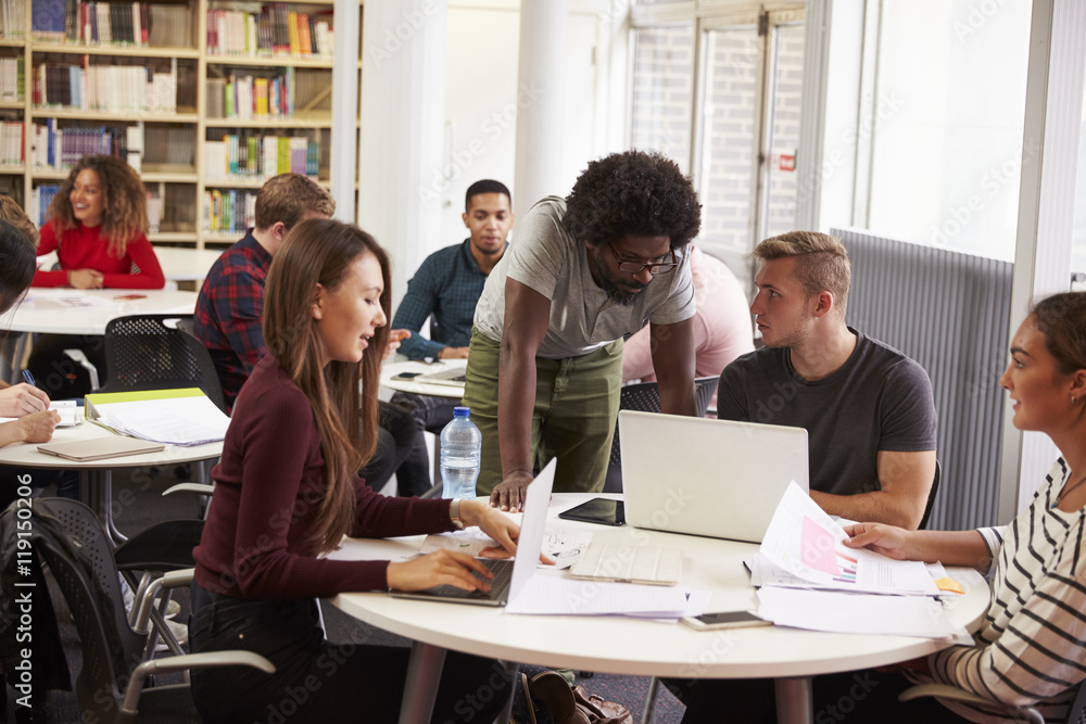 Busy University Library With Students And Tutor Busy University Library With Students And Tutor