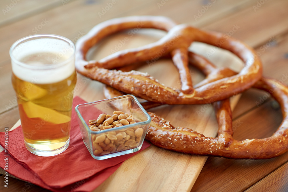 close up of beer, pretzels and peanuts on table close up of beer, pretzels and peanuts on table