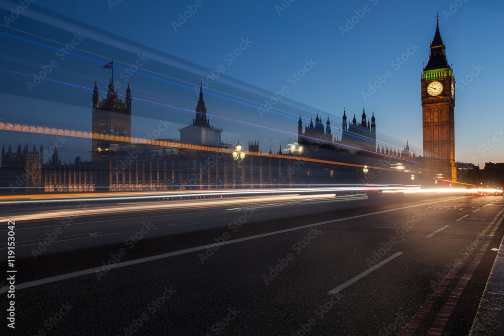 Big Ben at night with the lights of the cars passing 