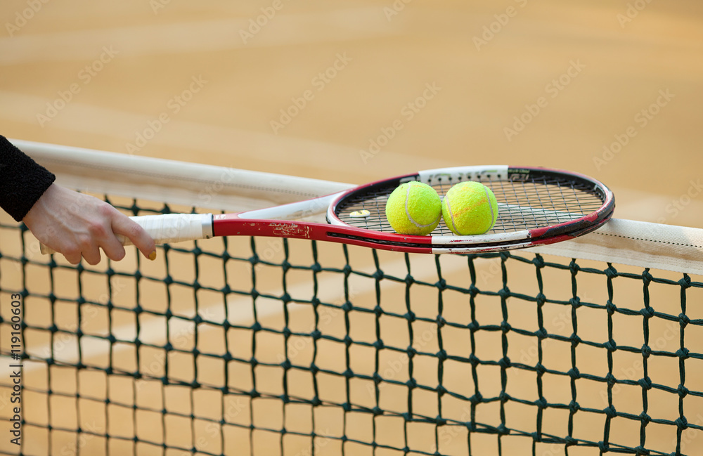 tennis racket with ball on clay court