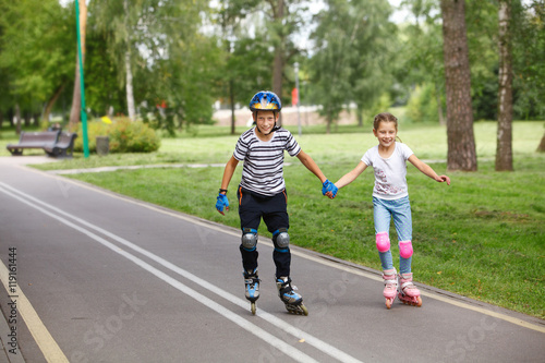 Brother and sister in a roller skates ride on the street