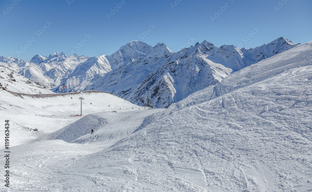 Ski and snowboard track in front of high mountains