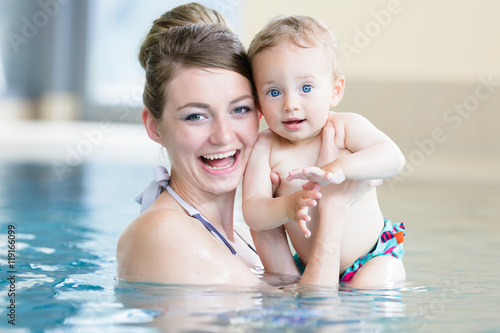 Mutter mit Ihrem neugeborenen Kind beim Babyschwimmen