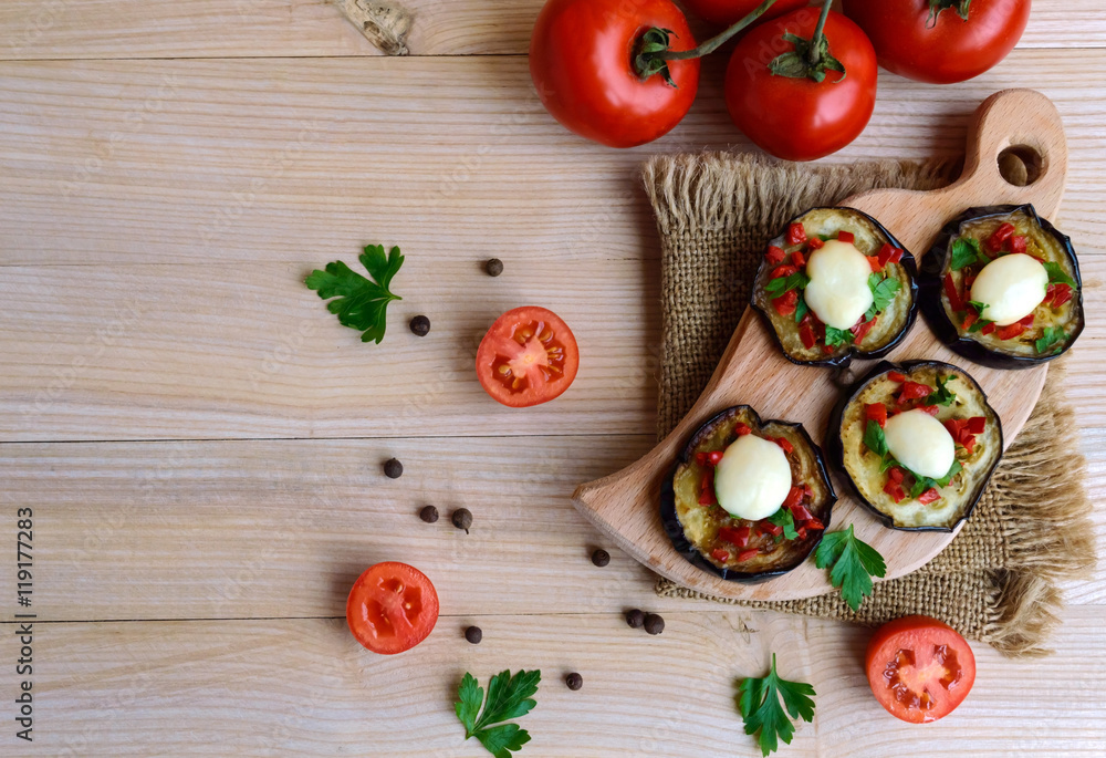 Spicy fried eggplant slices with red pepper, garlic, herbs and mozzarella. The top view. Spicy fried eggplant slices with red pepper, garlic, herbs and mozzarella. The top view.