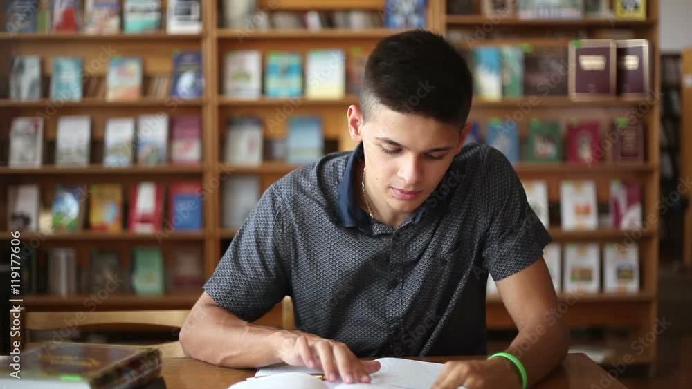 men doing notes from a book in the library