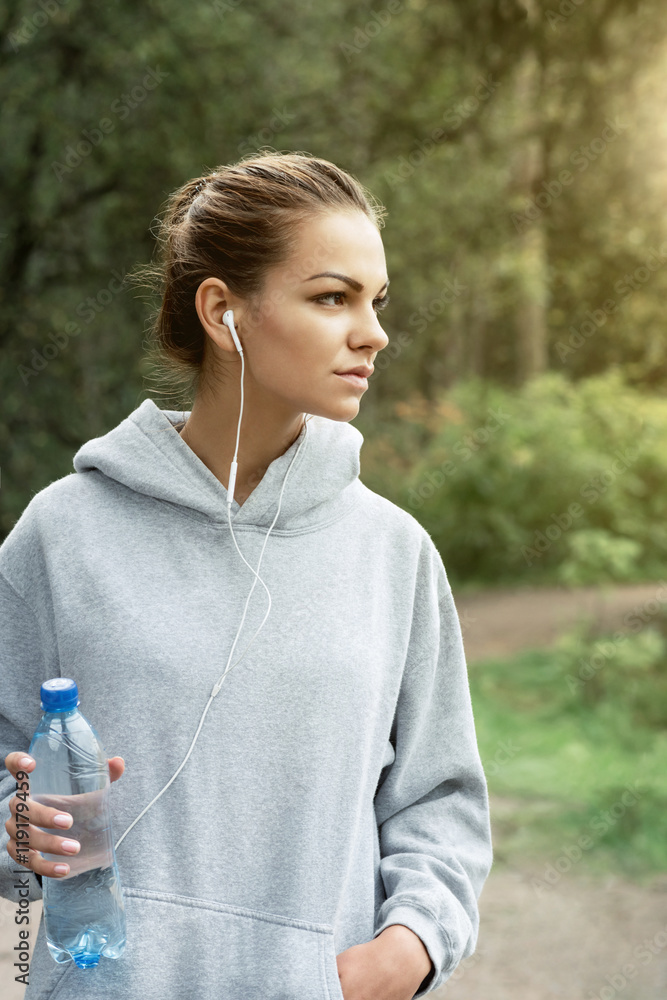 Beautiful woman in sportswear with a bottle of water in park Beautiful woman in sportswear with a bottle of water in park