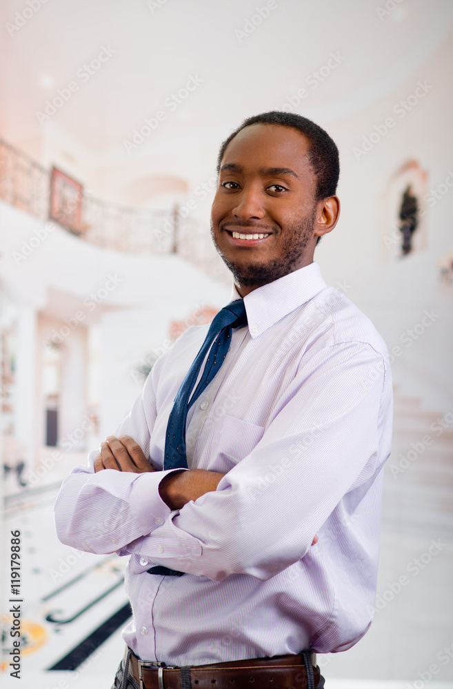 Handsome man wearing shirt and tie posing with arms crossed looking into camera smiling, business concept Handsome man wearing shirt and tie posing with arms crossed looking into camera smiling, business concept
