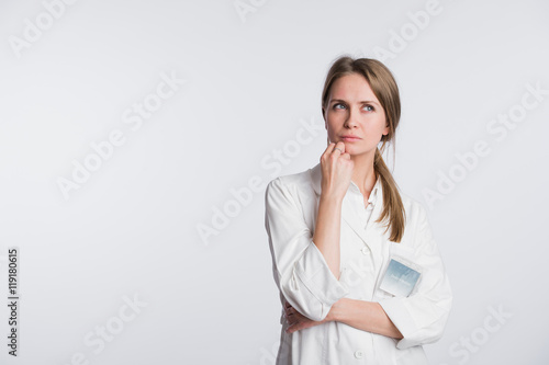 Thoughtful, Young Asian female doctor looking away isolated on white background © romankosolapov