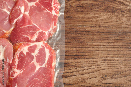 Foto Vacuum packed meat displayed on a wooden background
