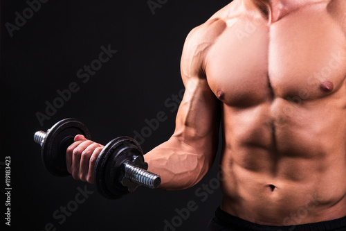 close up of muscular man doing exercises with dumbbell over grey