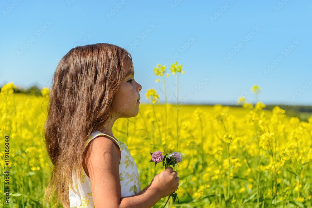 Fototapeta premium Portrait of a girl in rapeseed field