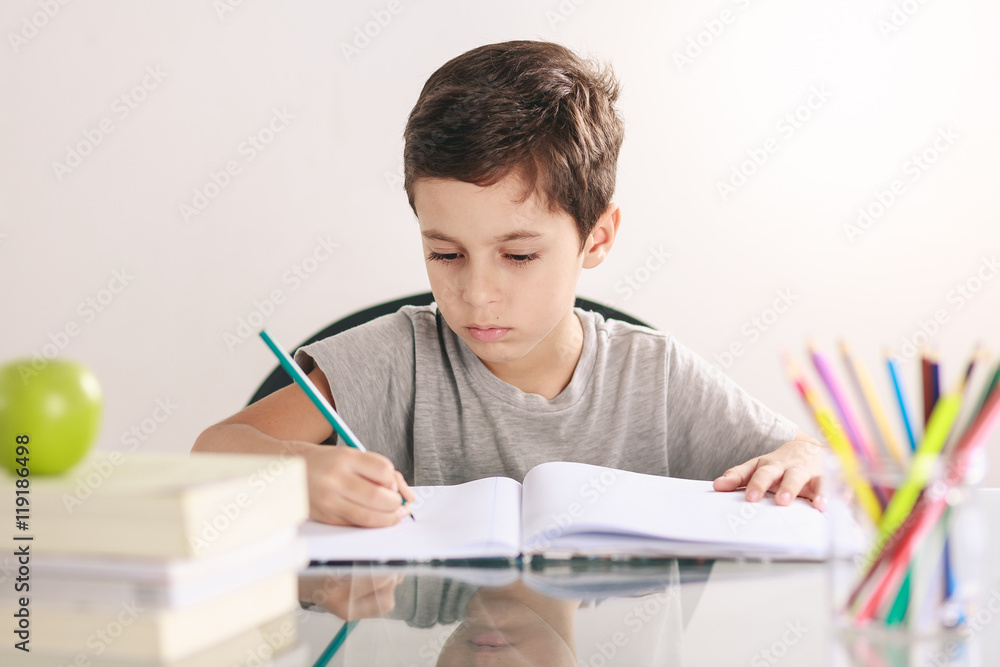 Candid portrait of a boy doing his homework and studying at home Candid portrait of a boy doing his homework and studying at home