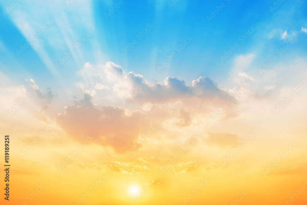 Obraz premium Zachód słońca na tle nieba, niebo zmieni kolory z niebieskiego na pomarańczowy.