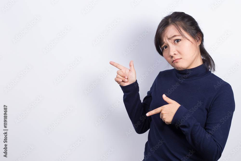 Confused woman pointing to the empty space Confused woman pointing to the empty space