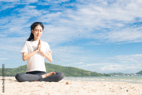 young woman practicing yoga on the beach © sunpt