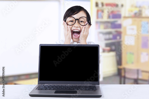 Girl with laptop laughing in class