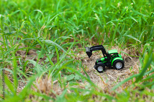 children's toy tractor on a green field