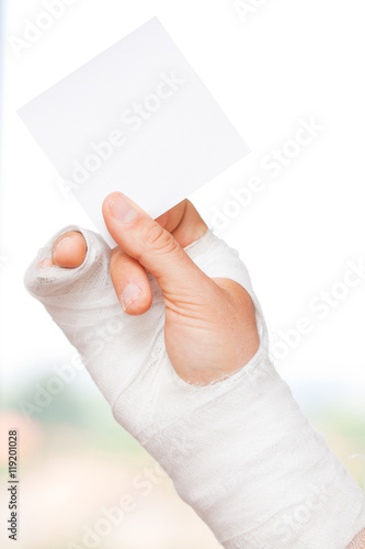 Broken hand holding a note