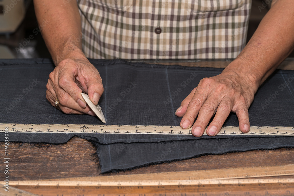 Tailor at work, drawing line on fabric with chalk
Tailor at work, drawing line on fabric with chalk