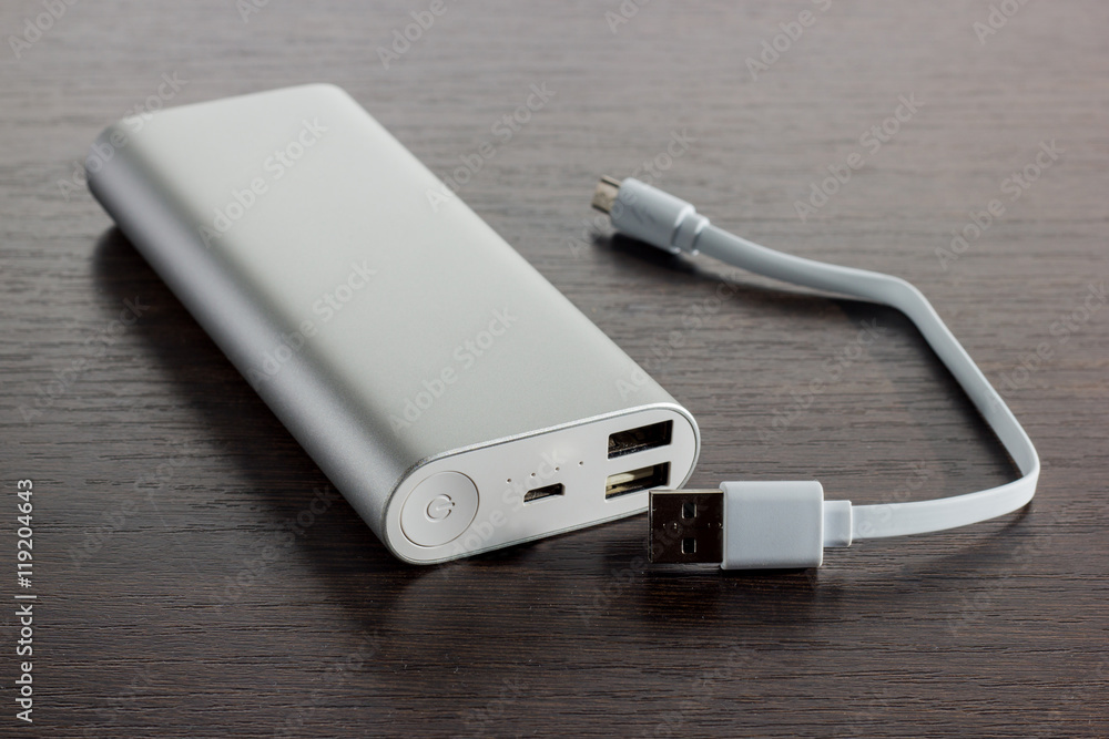 Silver aluminum power banks - dark wooden background Silver aluminum power banks - dark wooden background