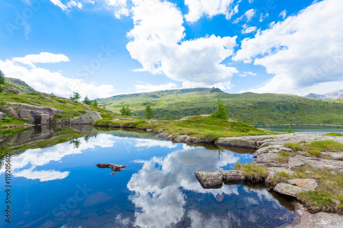 Italian mountain panorama, clouds reflected on alpine lake