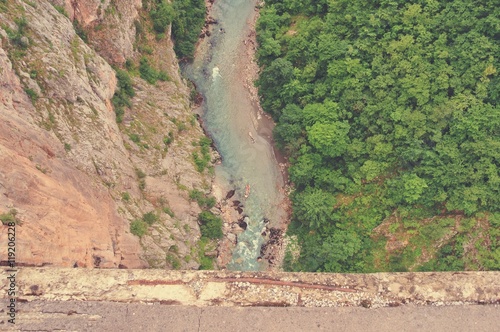 High angle view on the dramatic river canyon from the bridge; shot from directly above. Tara river gorge, Durmitor, Montenegro. Image filtered in faded, retro, Instagram style.
