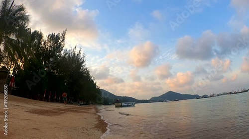 Time lapse: coastline at sea bay beach with blue sky, white clouds, hills and palms photo