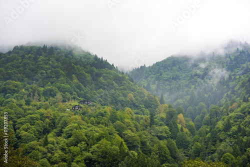 foggy day on mountains with plateau wooden houses