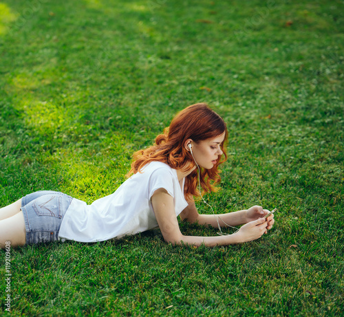 woman in headphones with the phone in the park © SHOTPRIME STUDIO